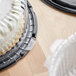 A close-up of a cake in a Choice 10" Low Dome Cake Display Container with a clear lid.