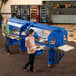 Two women using a Cambro navy blue salad bar with heavy-duty casters to carry trays of food.