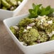 A bowl of cucumber salad with feta cheese and mint leaves.