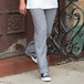 A person wearing Uncommon Chef houndstooth chef pants and sneakers.
