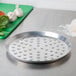 An American Metalcraft aluminum pizza pan with nibs on the bottom.