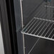 A black Continental Refrigerator back bar refrigerator with shelves.