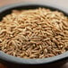 A bowl of Regal Cumin Seeds on a wooden table.