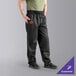 A person wearing Uncommon Chef black chef pants.