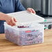 A woman using an Araven translucent plastic container with airtight lid to store cabbage.