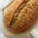 A loaf of bread with fennel seeds on a cutting board.