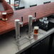 A woman at a bar counter using a Continental Kegerator to pour two glasses of beer.
