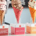 A close up of a Konery Pink Vanilla Waffle Cone filled with ice cream.
