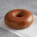 An Original Bagel Pumpernickel bagel on a napkin on a table.