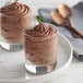 Two glasses of Knorr milk chocolate mousse on a plate.