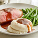 A plate of food with LeGout beef gravy, mashed potatoes, and meat.