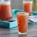 A glass of Lipton iced tea with ice on a table.