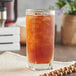 A glass of Lipton iced tea on a table with a napkin.