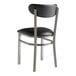 A Lancaster Table & Seating black metal chair with black vinyl seat and back and silver legs.