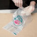 A person in plastic gloves holding a "Today's Catch" seafood bag.