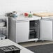 An Avantco stainless steel worktop refrigerator in a professional kitchen.