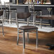 A metal chair with a clear coat finish and dark brown vinyl seat and back.