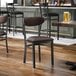 A black metal chair with a dark brown vinyl seat and backrest.