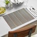 A table set with blue Metroweave vinyl placemats, plates, and silverware.