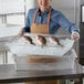 a person holding a tray of fish