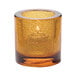 A Hollowick round amber glass tealight holder with a jewel design.