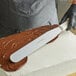 A person using a Dexter-Russell Sani-Safe straight spatula to frost a cake.
