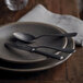 A plate with a Sola Baguette Vintage Stonewash coffee spoon and fork on it.