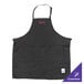 A black Chef Revival bib apron with a pink embroidered logo on the front pocket.