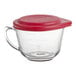An Anchor Hocking clear glass measuring cup with a red lid.