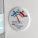 A white round Taylor HACCP wall thermometer with a red needle.