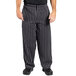 A person wearing Uncommon Chef black and white striped chef pants.