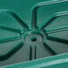 A green plastic Cambro container with a hole in the bottom on a table with a salad bar setup.