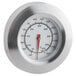 A close-up of a round silver Backyard Pro thermometer with a red needle.