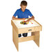 A boy playing with blocks on a Jonti-Craft wood frame LED lightbox table.