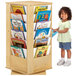 A child standing next to a Jonti-Craft revolving book rack filled with colorful books.