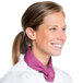 A woman wearing a white chef's coat and a mauve Intedge chef neckerchief.