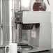 A Bloomfield Koffee King pourover coffee maker on a counter with a cup underneath.