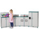 A little girl playing with a Rainbow Accents teal and gray toy kitchen.