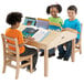 Three children sitting at a Jonti-Craft children's table reading books.