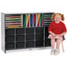 A girl sitting on a stool with a Rainbow Accents black storage cabinet full of books.