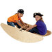 A couple of children playing on a Jonti-Craft wooden rocking boat.