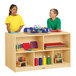 A boy and a girl standing at a Jonti-Craft wooden storage island in a classroom.