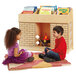 A boy and a girl sitting on the floor reading books in front of a wood storybook fireplace with a log fire and marshmallows.