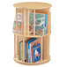 A Jonti-Craft Baltic Birch revolving wood bookshelf with books on it.