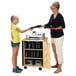 A woman and a girl using a Jonti-Craft wood laptop and tablet storage cart in a school.