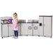 A little girl playing with a Rainbow Accents navy and gray toy kitchen set.
