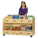 A young girl standing behind a Jonti-Craft 8-section wood book rack.