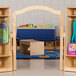 A wooden KYDZ Suite E-Height welcome arch in a room with wooden shelves and a bench.