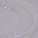 A close-up of a Fineline Flairware clear plastic plate with a rippled edge.