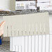 A hand holding a white Short Metro Tote Box Divider package.